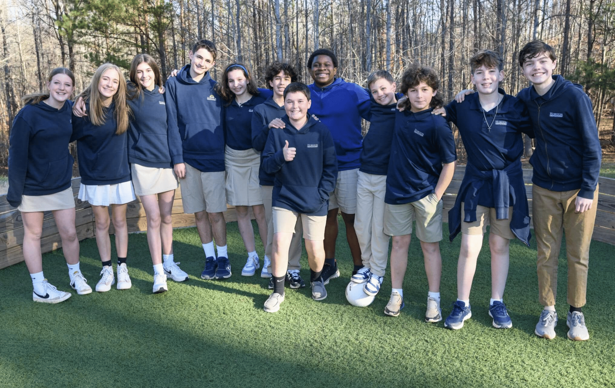middle school students in uniform smiling at camera