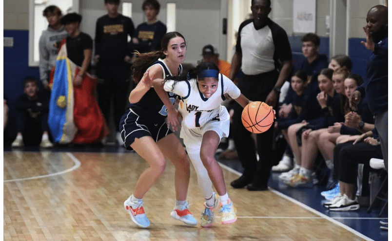 girl dribbling basketball in varsity game