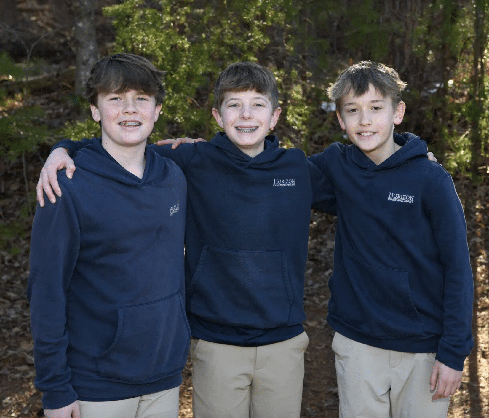 middle school aged boys posing and smiling for camera
