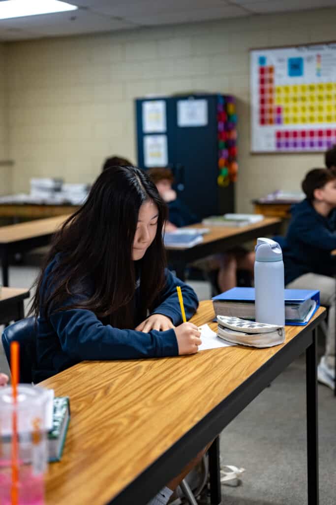 HCA girl high school student writing at table