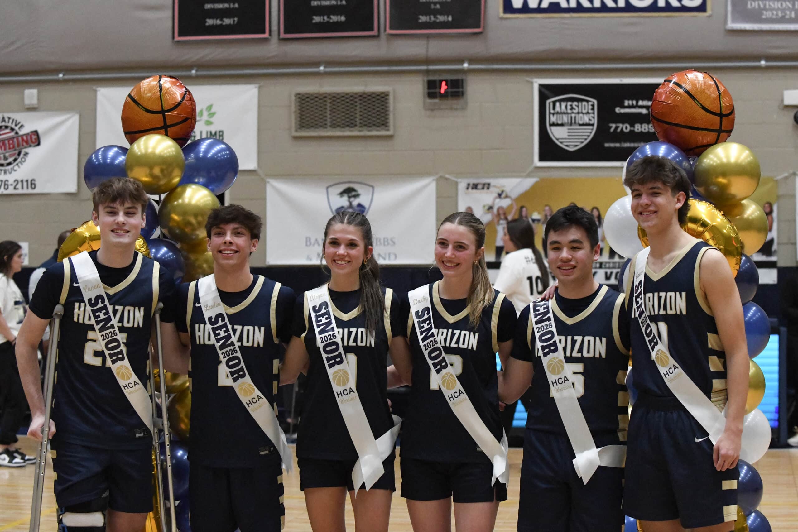 HCA senior boys and girls basketball players smiling with sashes on that say 'Senior'.