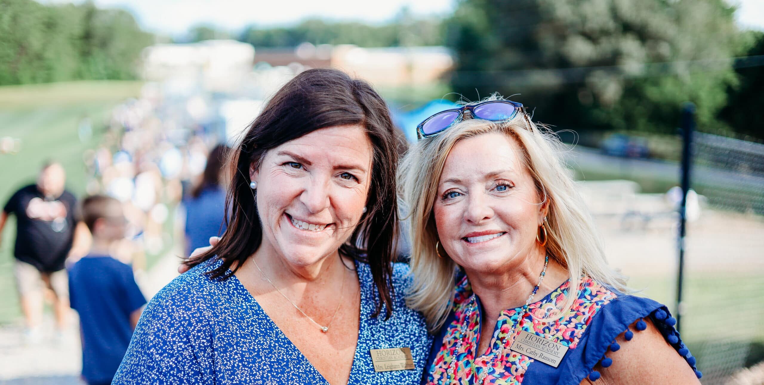 Two HCA staff members smiling outside