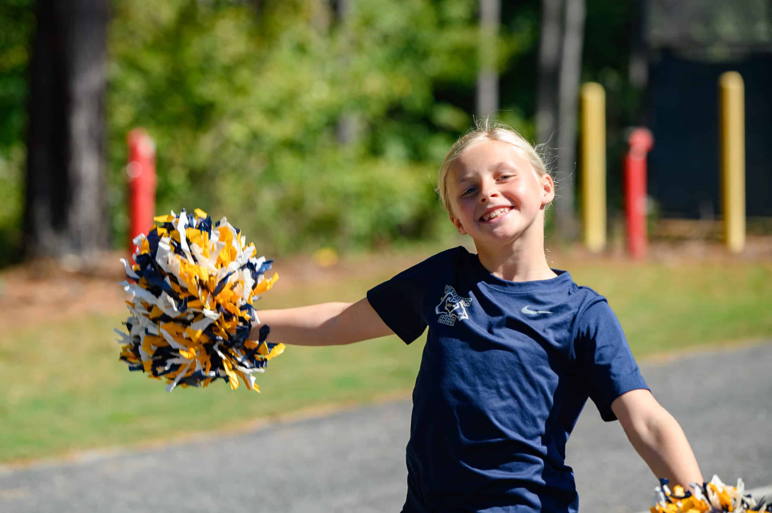 Elementary/Middle girl student smiling with cheer pom poms