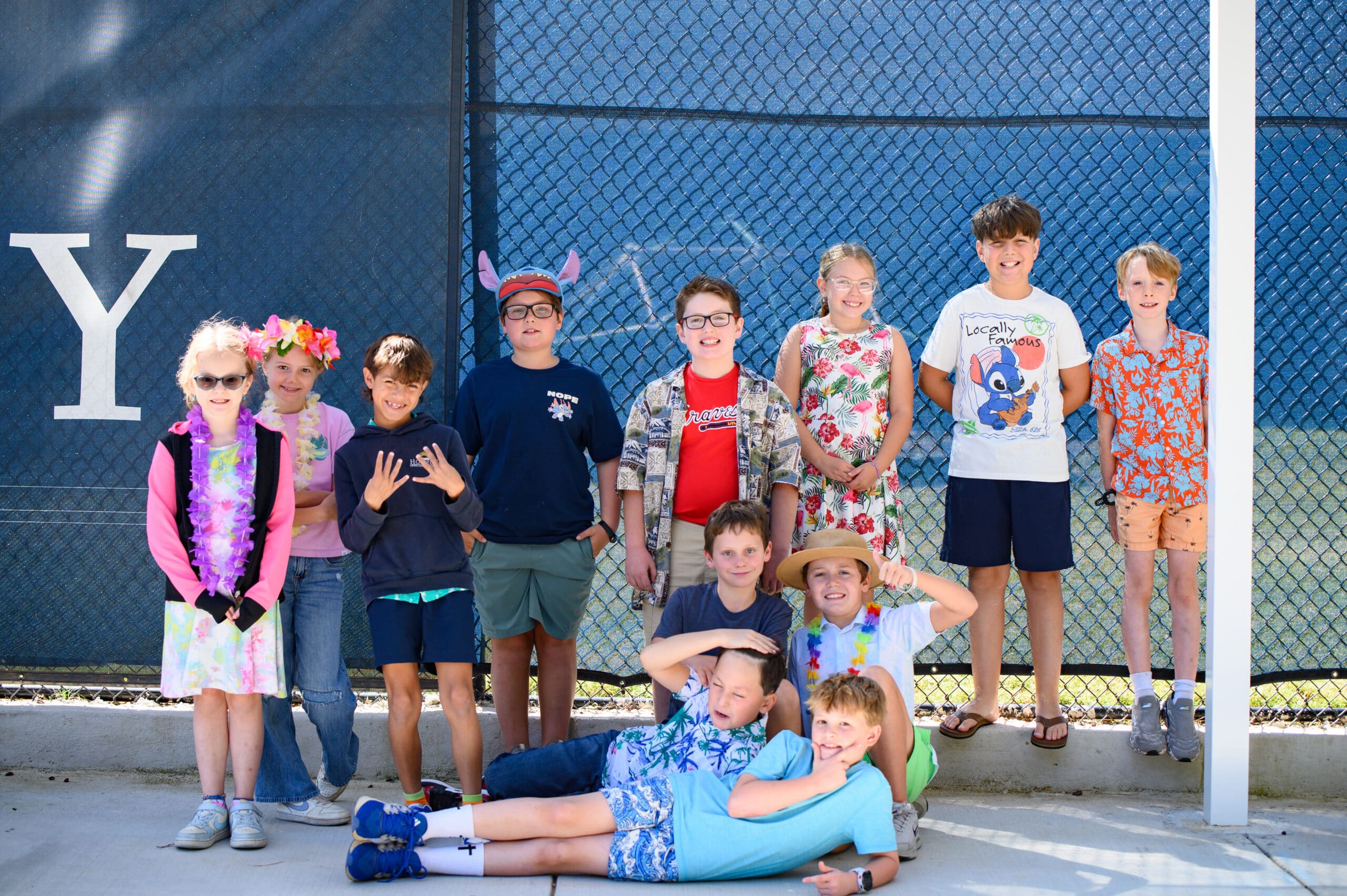 Ground of Elementary students smiling and wearing Hawaiian accessories