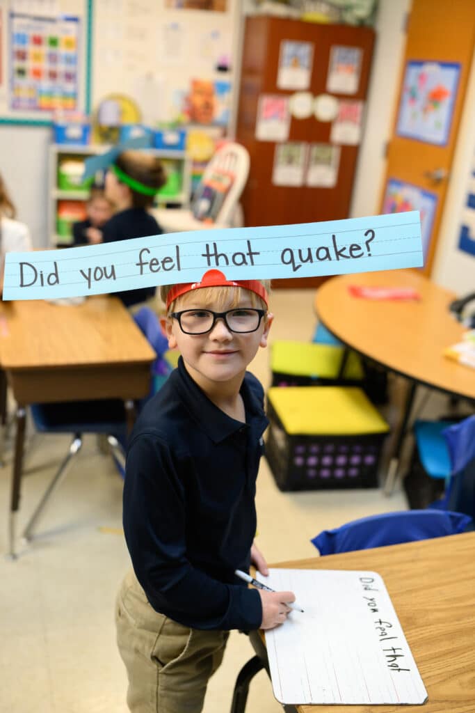 HCA elementary student doing writing exercise on dry erase board